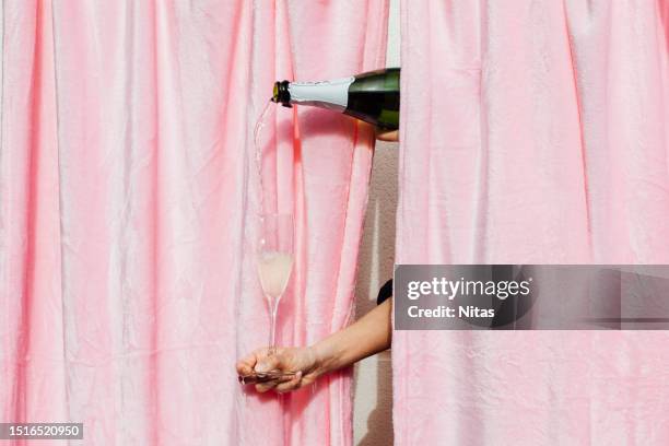 woman pouring champagne in flute glass - champagne toast stock-fotos und bilder