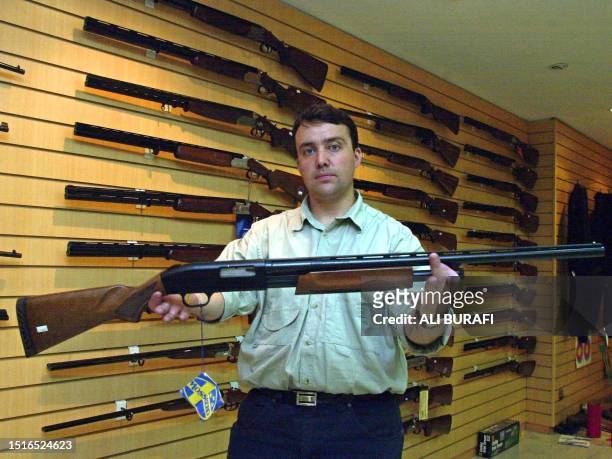 Gun shop manager Julio Caroniholds holds one of the stores more popular item, a 12 caliber rifle 24 January 2003 in Buenos Aires, Argentina. The...