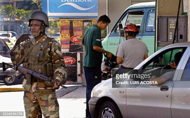 Venezuelan army soldier stands guard outside a gas station in Caracas, Venezuela, 09 December 2002. Oil prices rose 09 December after hopes of an end...