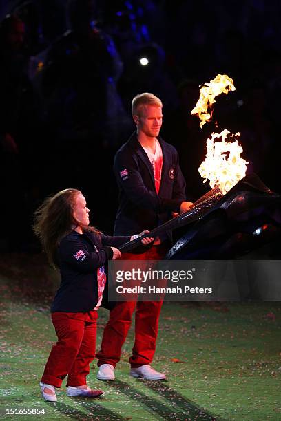 Swimmer Eleanor Simmonds and athlete Jonnie Peacock light torches from the flame of the Paralympic cauldron as it is extinguished during the closing...