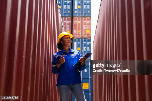 black female worker using a laptaop while working in a commercial port - customs agent stock pictures, royalty-free photos & images