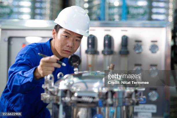 higher safety and reliability of boiler and its equipment with preventive maintenance plan in your water plant. a male japanese maintenance engineer check pressure gauge of water pump to reduce downtime of production line. - durability stock pictures, royalty-free photos & images