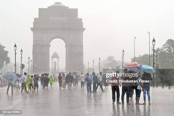 Visitors seen during monsoon rains at Kartavya Path near the India Gate, on July 9, 2023 in New Delhi, India. Delhi-NCR was drenched with heavy rain...