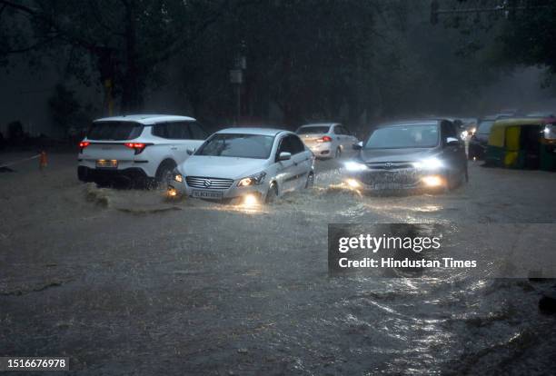 Commuters move through a water logged stretch amid heavy rains at Sarojini Nagar, on July 9, 2023 in New Delhi, India. Delhi-NCR was drenched with...