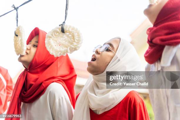 indonesian girls  competing eating cracker - eating competition stock pictures, royalty-free photos & images