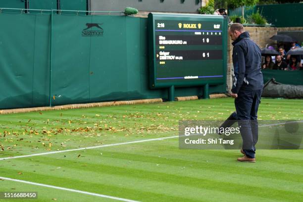 Member of the ground staff clear the court after protesters interrupted the Men's Singles first round match between Sho Shimabukuro of Japan and...