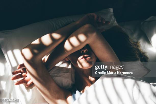 sad and depressed woman lying in bed at home. - stress emotivo imagens e fotografias de stock