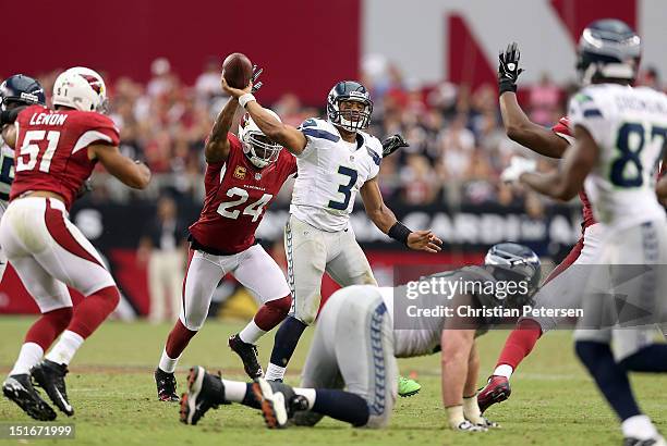 Quarterback Russell Wilson of the Seattle Seahawks throws a pass under pressure from strong safety Adrian Wilson of the Arizona Cardinals during the...