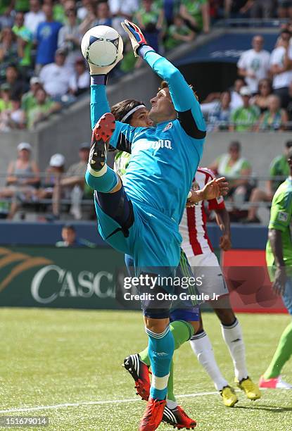 Goalkeeper Dan Kennedy of Chivas USA blocks a shot by Zach Scott of the Seattle Sounders FC at CenturyLink Field on September 8, 2012 in Seattle,...