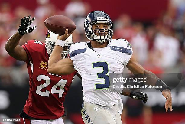 Quarterback Russell Wilson of the Seattle Seahawks throws a pass under pressure from strong safety Adrian Wilson of the Arizona Cardinals during the...