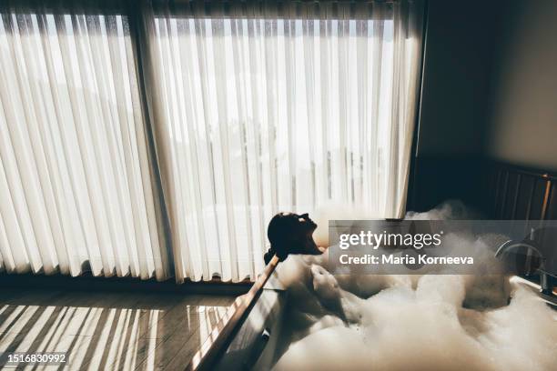 woman relaxing in hot tub in a hotel room. - bubbelbad stockfoto's en -beelden