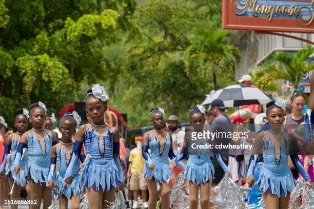 costumed group of young girls parading and dancing in the street, carnival, st. john, 2023 - cruz bay harbor stock pictures, royalty-free photos & images