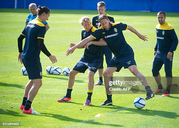 Sweden national football team's player Zlatan Ibrahimovic watches Ola Toivonen and Jonas Olsson vying for the ball during a training session with the...
