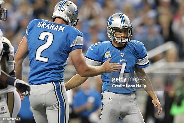 Jason Hanson of the Detroit Lions kicks a field goal in the third quarter and is congratulated by teammate Ben Graham during the season opener...