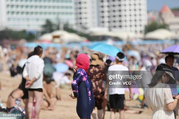 Woman wears facekini at a bathing beach during a heat wave on July 5, 2023 in Qingdao, Shandong Province of China.