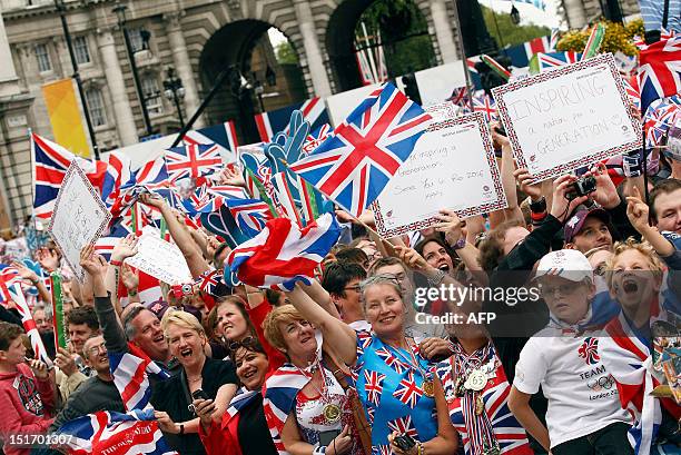 Crowds in Trafalgar Square in front of Admiralty Arch wave and cheer as floats pass during a parade celebrating Britain's athletes who competed in...