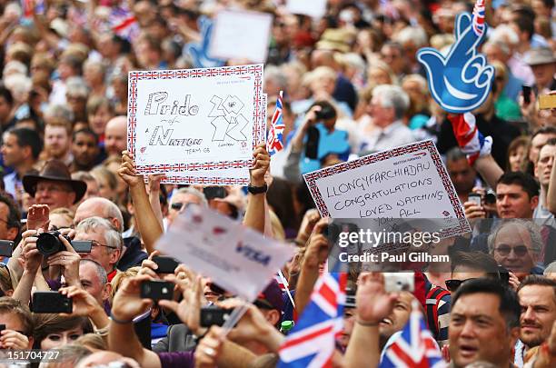 Members of the public cheer on the athletes as they take part in the London 2012 Victory Parade for Team GB and Paralympics GB athletes through...