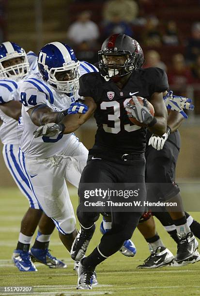 Stepfan Taylor of the Stanford Cardinal breaks the arm tackle of Kenny Anunike of the Duke Blue Devils during the first quarter of an NCAA football...