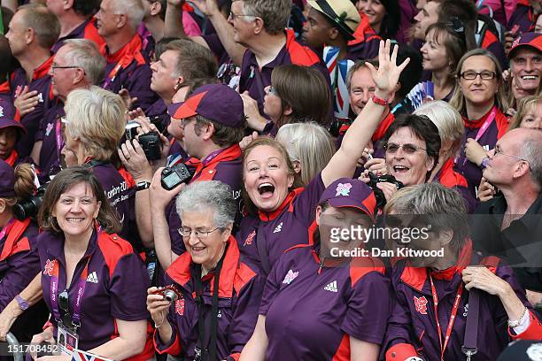 Volunteers cheer during the London 2012 Victory Parade for Team GB and Paralympic GB athletes on September 10, 2012 in London, England.