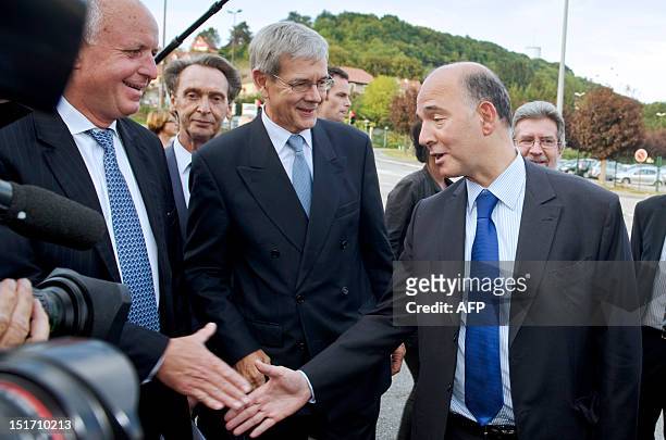 French Economy, Finance and Foreign Trade Minister Pierre Moscovici shakes hand with Thierry Peugeot , the Chairman of Supervisory Board of PSA...