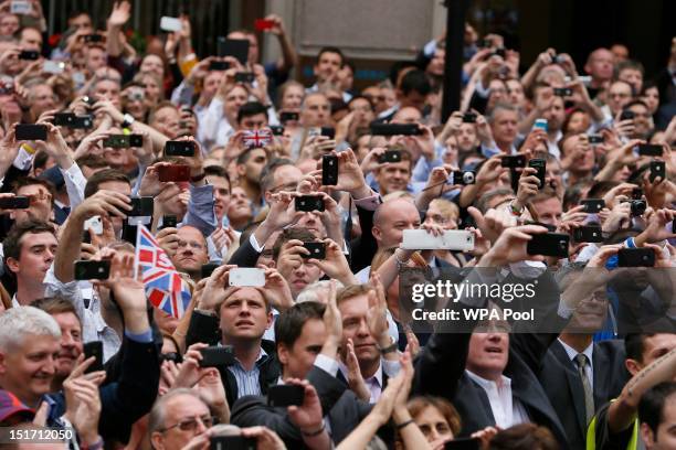 Spectators take photographs during the London 2012 Victory Parade for Team GB and Paralympic GB athletes on September 10, 2012 in London, England.