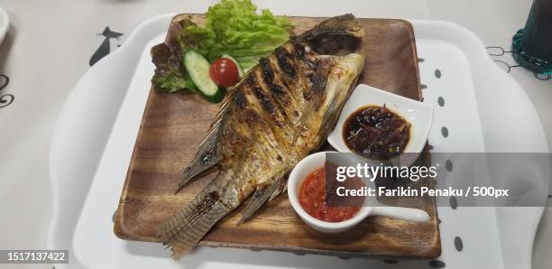 high angle view of sea bass and salad in plate on table - comida-para-peixe imagens e fotografias de stock