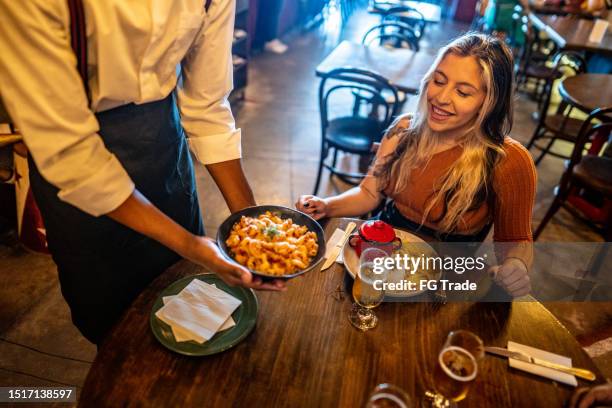 waiter serving food to customer at a restaurant - carrying table stock pictures, royalty-free photos & images