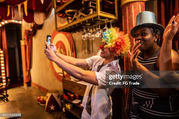 freunde, die ein selfie machen oder mit dem handy in einem zirkus filmen - zirkus stock-fotos und bilder