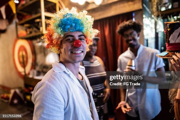 portrait of a young man with friends at circus - clown's nose stock pictures, royalty-free photos & images