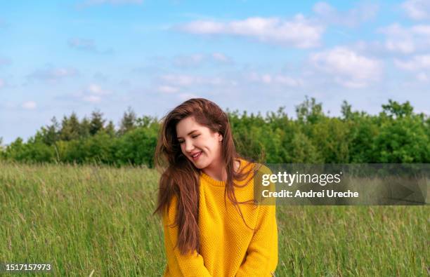 woman with a cute smile enjoying nature. young woman in sweatshirt portrait - femininity stock-fotos und bilder