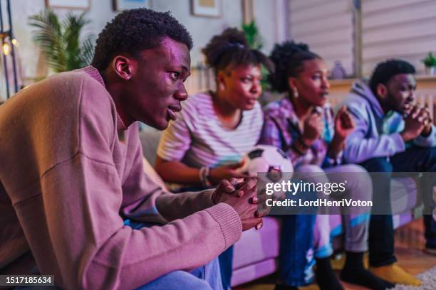 friends watching a soccer match at home - european championship stock pictures, royalty-free photos & images