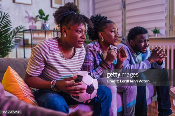 friends watching a soccer match at home - european championship stock pictures, royalty-free photos & images