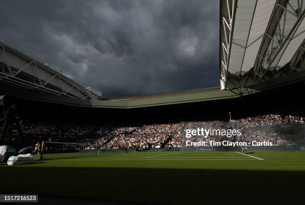 Brief moment of sunshine lights up Centre Court and the gathering clouds on a rain-interrupted day as Novak Djokovic of Serbia plays against Jordan...