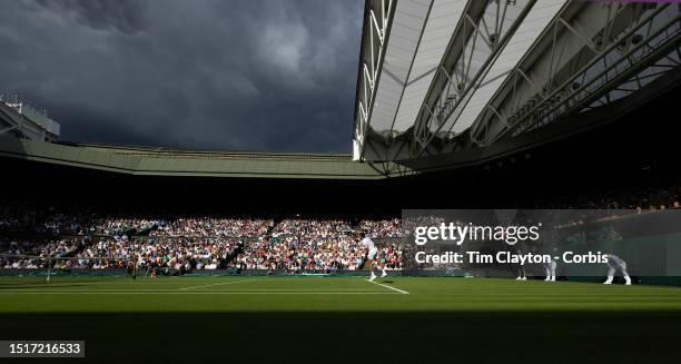 Brief moment of sunshine lights up Centre Court and the gathering clouds on a rain-interrupted day as Novak Djokovic of Serbia plays against Jordan...