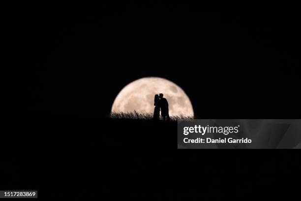 romance under the moon, an enamored kiss illuminated by the full moon - vollmond stock-fotos und bilder