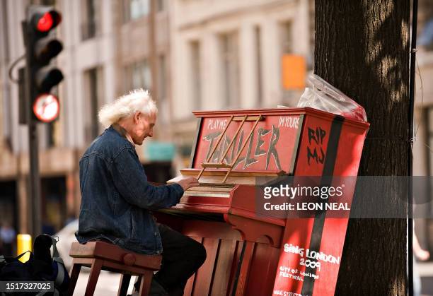 Man plays on a "street piano", in central London, on July 3, 2009. 30 Street Pianos have been placed all around London as part of the 'Play Me I'm...