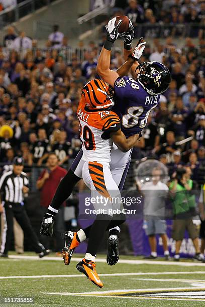Tight end Dennis Pitta of the Baltimore Ravens catches a touchdown pass in front of cornerback Leon Hall of the Cincinnati Bengals during the second...