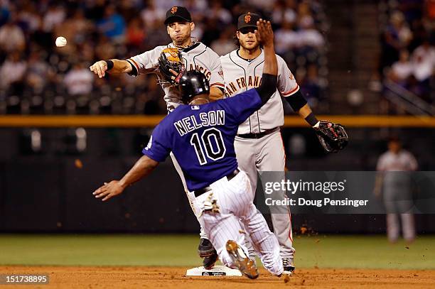 Second baseman Marco Scutaro of the San Francisco Giants turns a double play on Chris Nelson of the Colorado Rockies on a ground ball by Charlie...