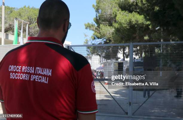 Member of Croce Rossa stands in front of the entrance to the Lampedusa Hotspot on July 04, 2023 in Lampedusa, Italy. The Contrada Imbriacola hotspot...