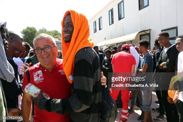 Member of Croce Rossa interacts with newly arrived migrants at the Lampedusa Hotspot on July 04, 2023 in Lampedusa, Italy. The Contrada Imbriacola...