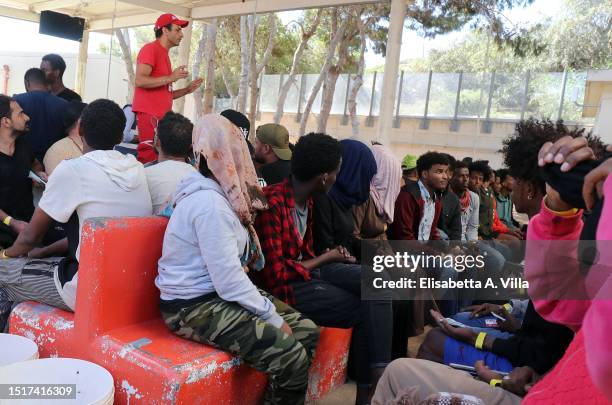 Member of Croce Rossa interacts with newly arrived migrants at the Lampedusa Hotspot on July 04, 2023 in Lampedusa, Italy. The Contrada Imbriacola...