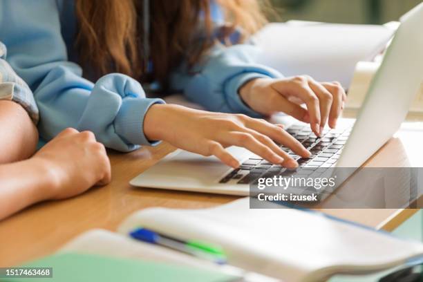 teenagers typing on laptops in the classroom - female high school student stock pictures, royalty-free photos & images