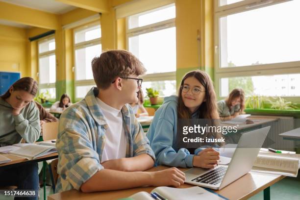 teenagers using laptop during lesson - positive emotion stock pictures, royalty-free photos & images