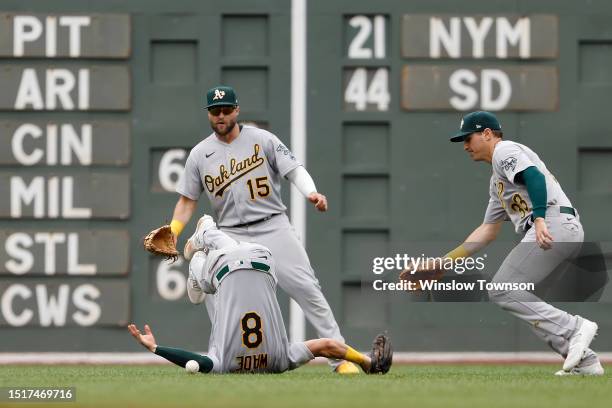 Tyler Wade of the Oakland Athletics tumbles as he can't make the catch on a bloop single by Masataka Yoshida of the Boston Red Sox as Seth Brown and...