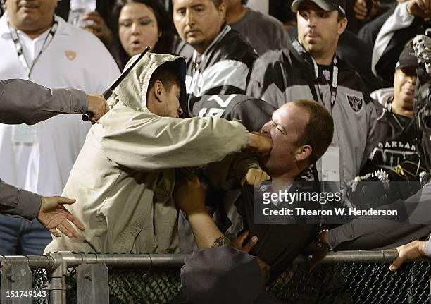Two fans fight during the season opener of an NFL football game between the San Diego Chargers and Oakland Raiders at Oakland-Alameda County Coliseum...