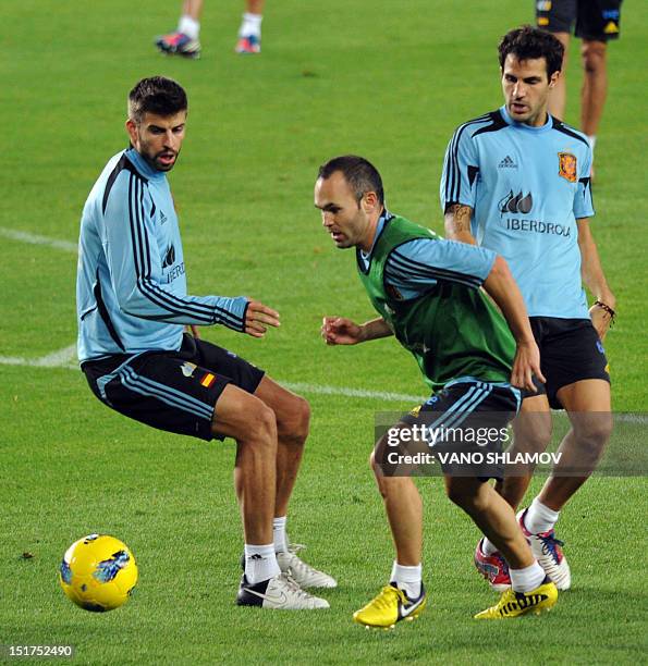 Spain's national soccer team players Andres Iniesta , Gerard Pique and Cesc Fabregas take part in a training session at Boris Paichadze stadium in...