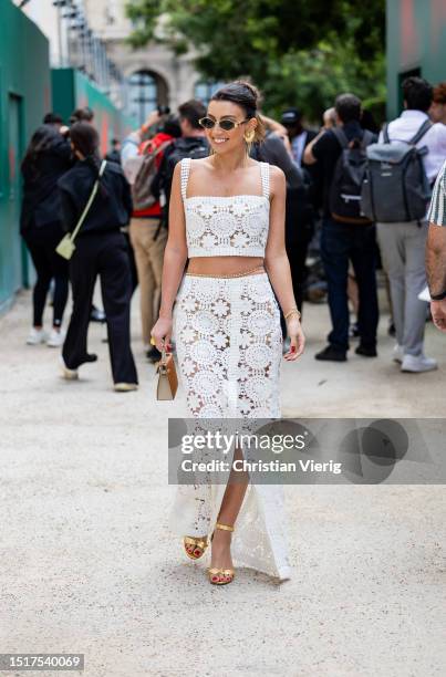 Guest is seen wearing laced white cropped top, skirt with slit outside Elie Saab during the Haute Couture Fall/Winter 2023/2024 as part of Paris...