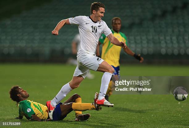 Chris Killen of New Zealand takes the ball over the top of Freddie Kini of the Solomon Islands during the FIFA World Cup Qualifier match between the...