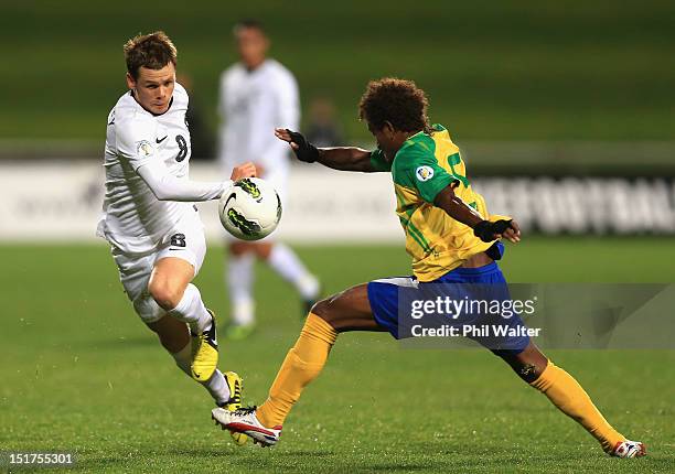 Michael McGlinchey of New Zealand kicks the ball past Freddie Kini of the Solomon Islands during the FIFA World Cup Qualifier match between the New...