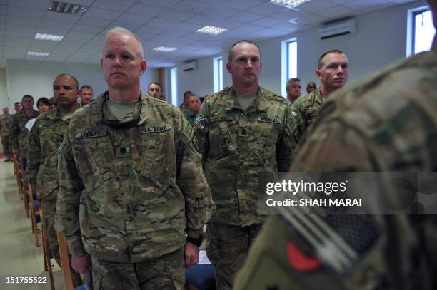 Soldiers with the NATO-led International Security Assistance Force stand as the US national anthem is played during a memorial ceremony in...